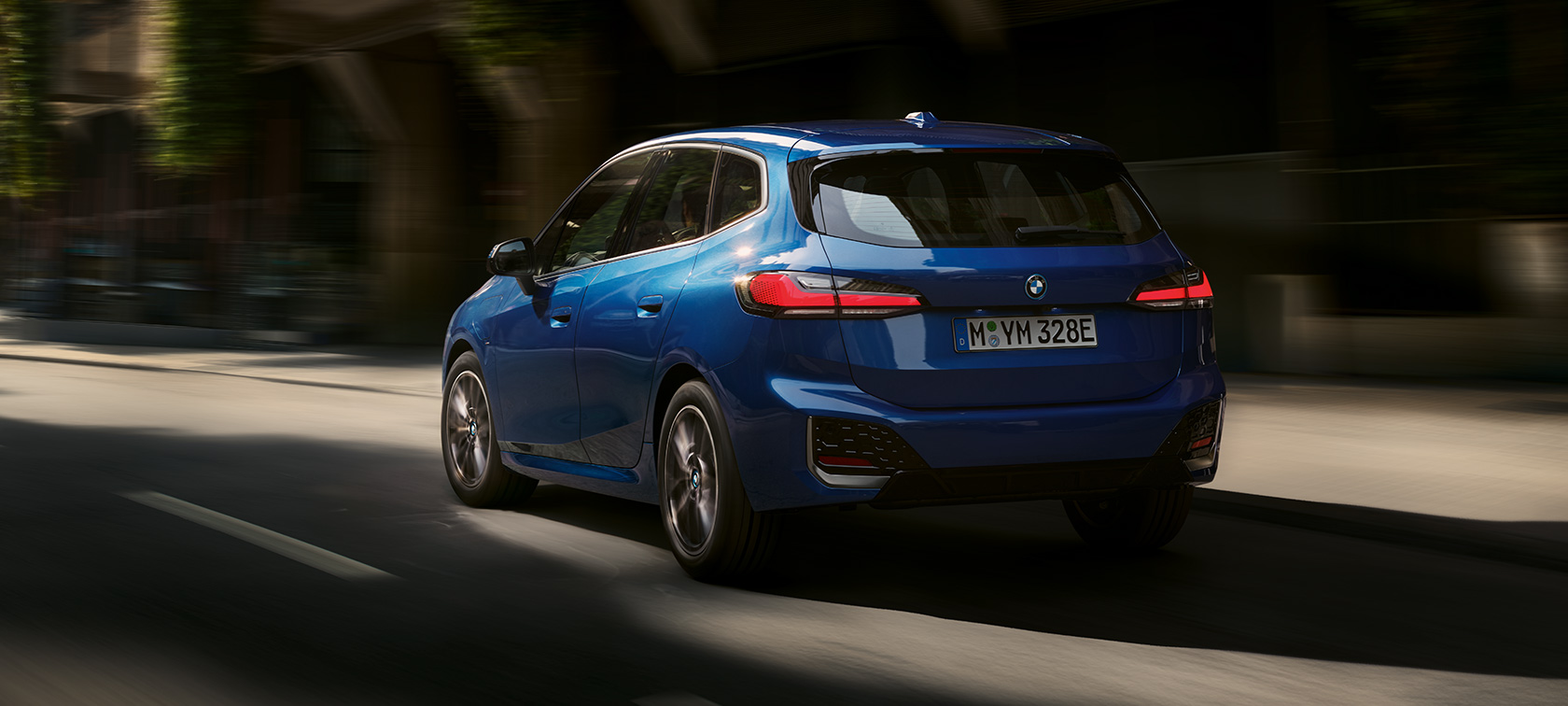 BMW 2er Active Tourer 230e Plug-In Hybrid U06 2021 M Portimao Blau metallic Dreiviertel-Heckansicht fahrend in der Stadt